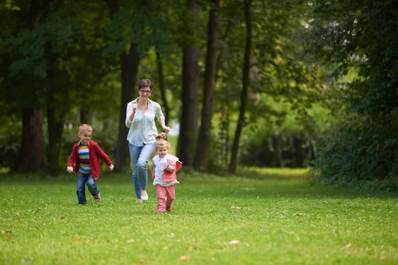 happy family playing together outdoor  in park mother with kids  running on grass